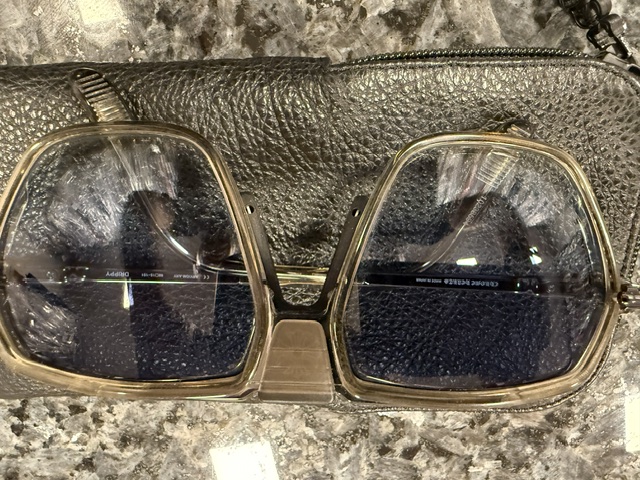 A pair of Chrome Hearts sunglasses with heavy acetate frames on a leather case