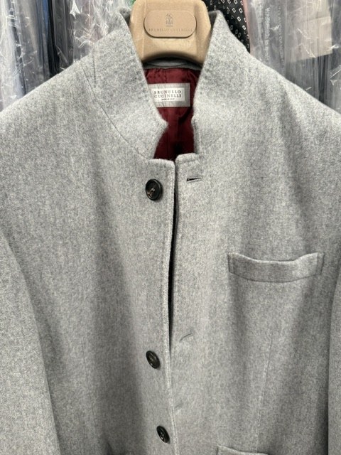A grey Brunello Cucinelli cashmere coat on the hanger