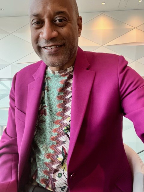 Darryl Matthew in a magenta jacket over a printed shirt