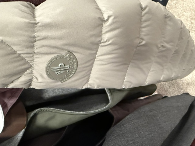 A stone-coloured Moncler down jacket with the house roundel on the chest