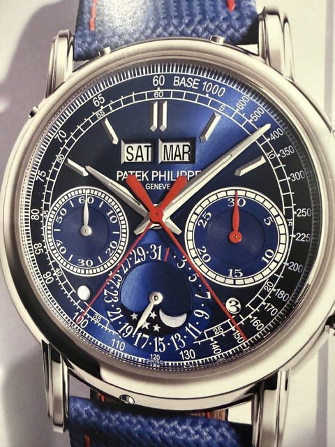 A Patek Philippe perpetual calendar chronograph with a deep blue dial, day and month apertures, moon phase, and a blue strap.