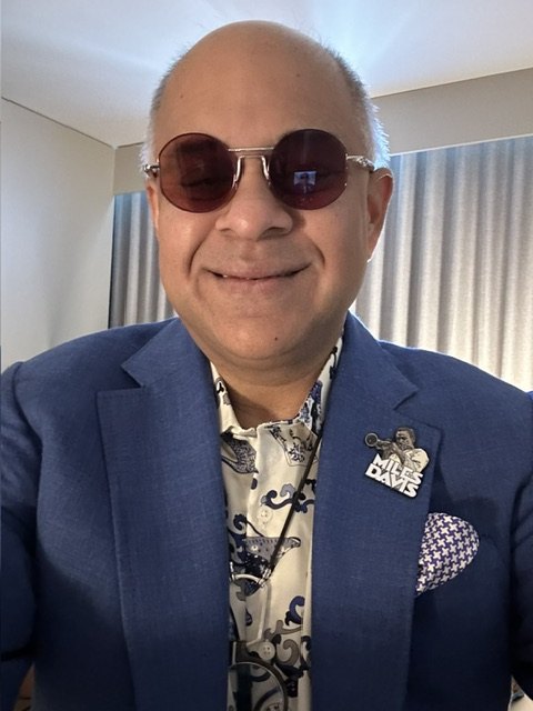 Sri Ramaswami in round sunglasses and a blue blazer, WSY Edit